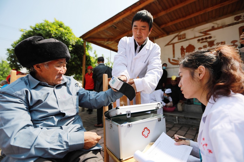 醫(yī)務(wù)人員和志愿者在貴州省黔西市林泉鎮(zhèn)敬老院為老人量血壓、測血糖。